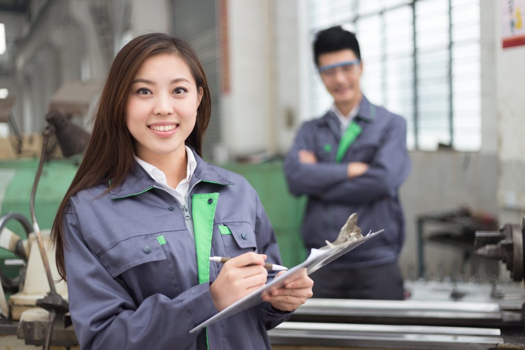 young chinese man and woman work in motor manufacturing factory